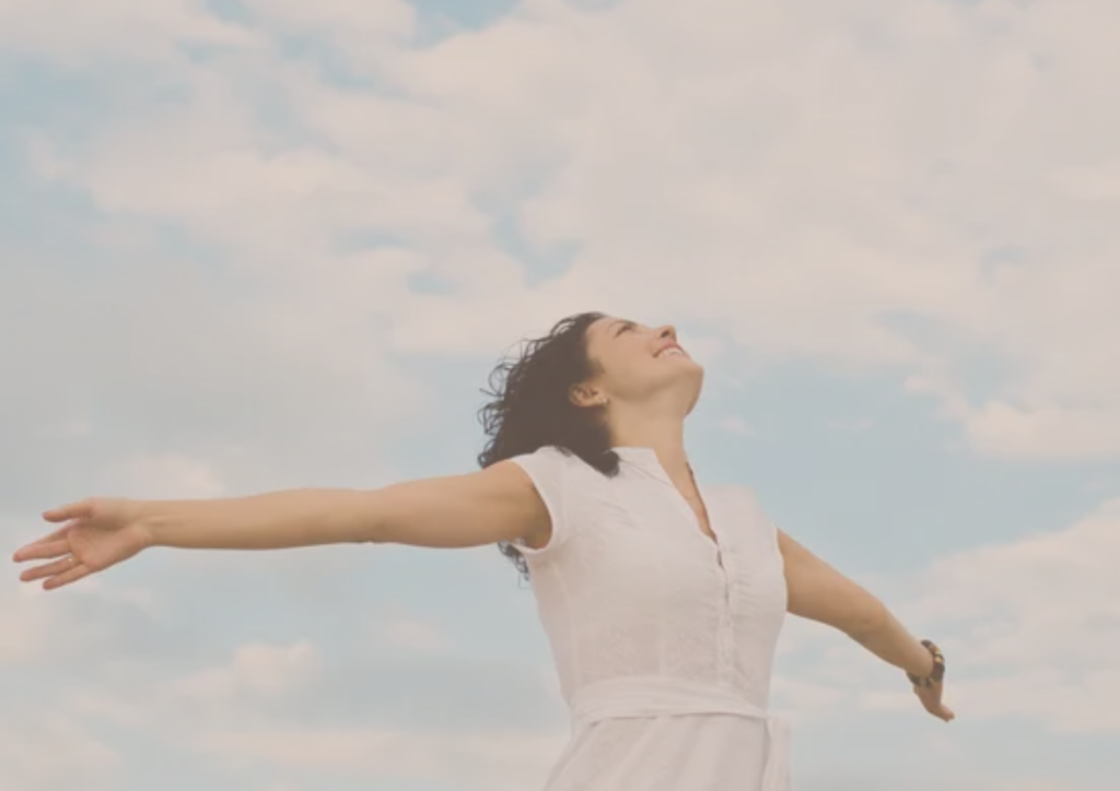 Une femme heureuse qui ouvre grand les bras